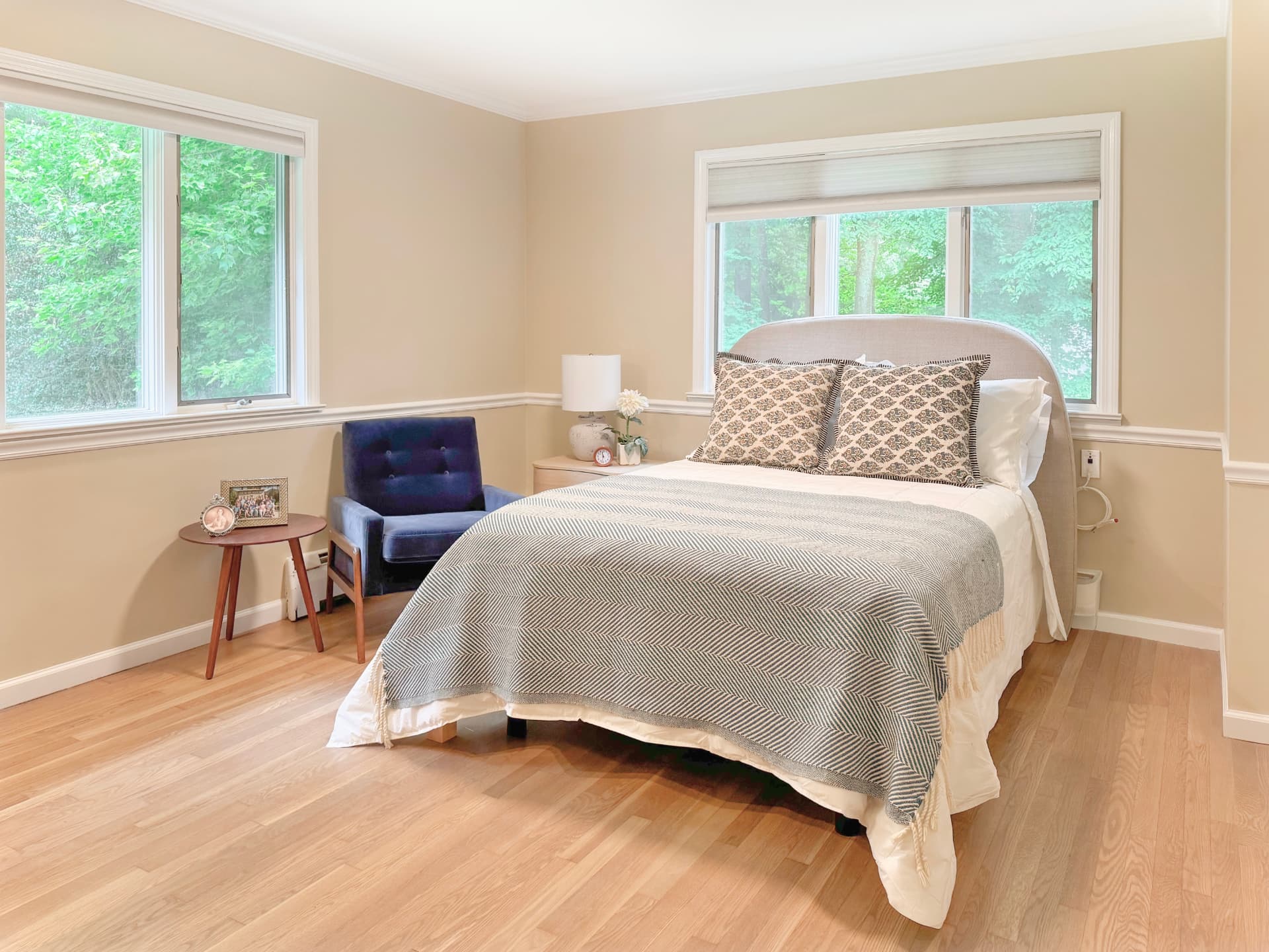 A calm, sunlit resident bedroom with woodland views